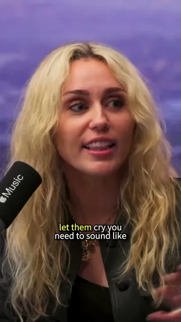 A short of Miley Cyrus talking into a studio microphone